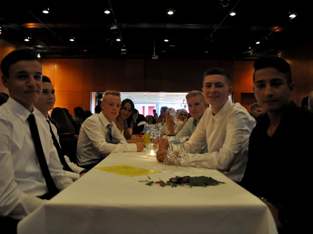 Jugendliche im Anzug an der festlichen Tafel.